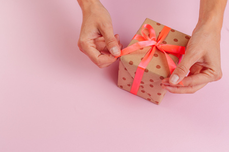 Woman holding gift box on color backgroundの写真素材
