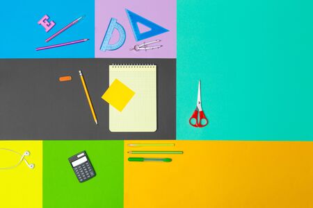 school supplies at colorful paper background