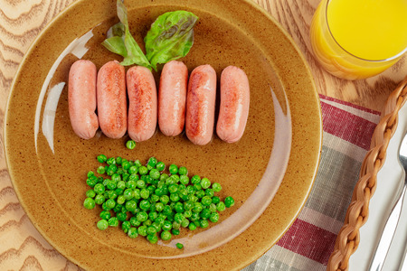 Fried sausages with green peas breakfast dish close upの写真素材