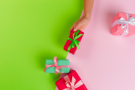 Woman holding gift box on color backgroundの写真素材