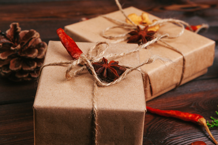 Christmas composition. Christmas gift, knitted blanket, pine cones, fir branches on wooden background.の写真素材