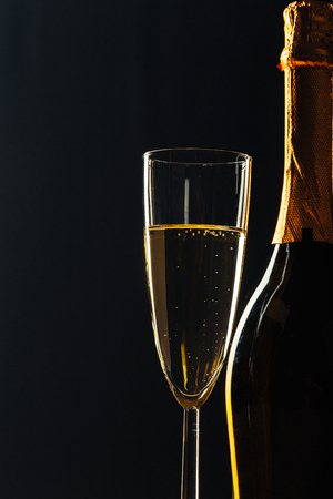 bottle of champagne and glasses over dark backgroundの写真素材