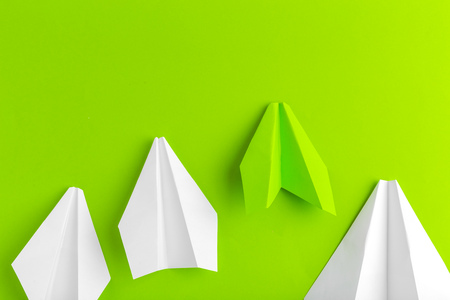 Flat lay of a paper plane on green pastel color background
