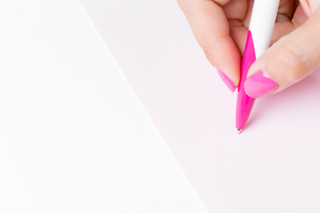 Female hand holding a pen close upの写真素材