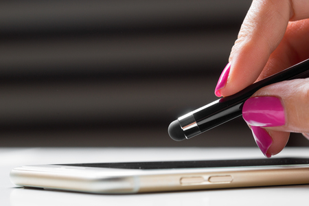 woman working with pen on smart mobile phoneの写真素材