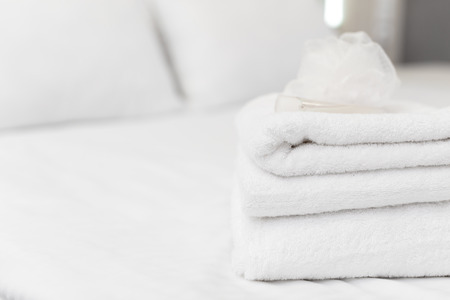Clean towels on bed at hotel roomの写真素材