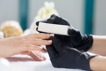 Woman hands receiving a manicure in beauty salonの写真素材