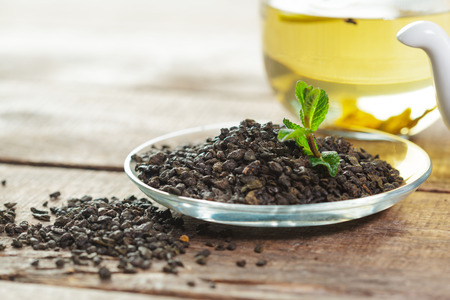 cup of black tea with mint leaves on a wooden tableの写真素材