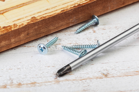 screw screwed into a wooden barの写真素材