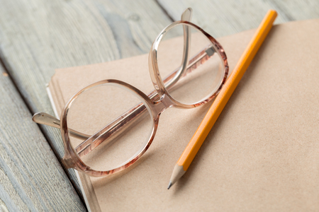 notepad and eyeglasses on the tableの写真素材