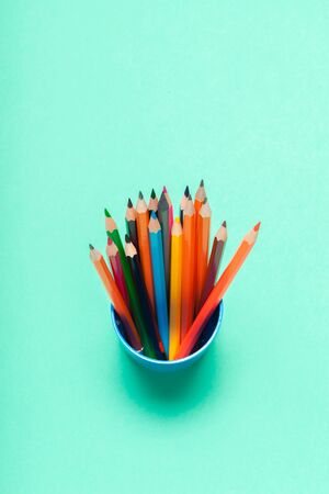 Colorful pencils in a cup on blue background top view. creative photoの写真素材