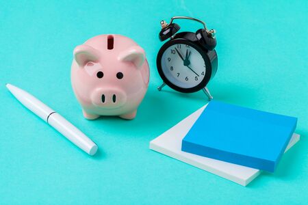 Piggy bank save coin and alarm clock, time and money concept.の写真素材