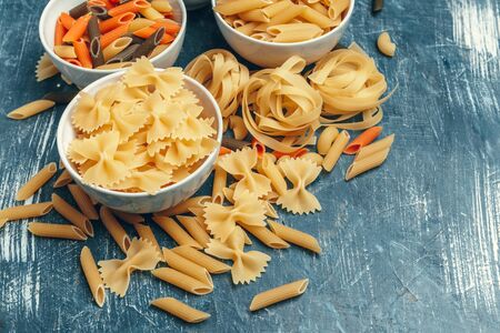 Different pasta types in bowls on the table. creative photo.