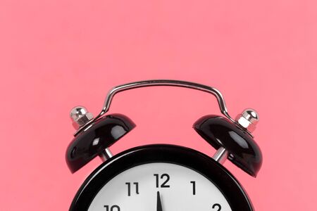 Vintage alarm clock on a bright pink background. creative photo.の写真素材