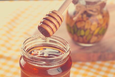 Honey background. Sweet honey in glass jar on wooden background.の写真素材