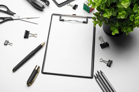 Home office workspace mockup with green plant and stationery accessories with copy space background.
