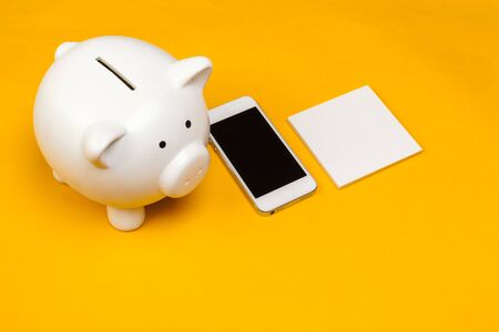 Piggy bank with mobile phone. creative photo.の写真素材