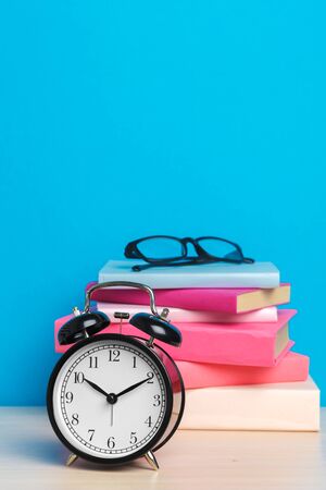 Back to school background with books and alarm clockの写真素材