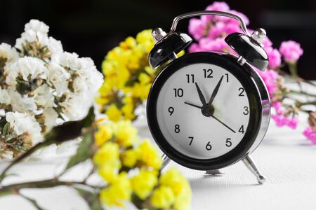 Spring Time Change Background with alarm clock and flower branchesの写真素材