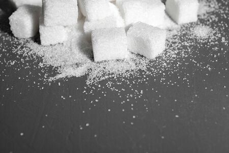 White sugar cubes over black background close up
