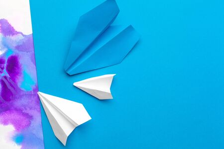 white paper airplane on a color block paper background