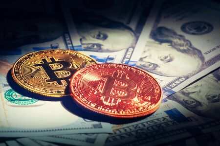 Golden bitcoin coins on a paper dollars money. creative photo.の写真素材