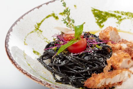 Fresh black tagliolini pasta with chicken in herbs. Creative photo.の写真素材