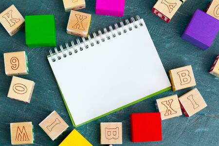 Notepad on wooden table and wood alphabet blocks