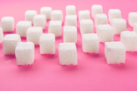 Cubes of sugar on bright pink background. creative photo.の写真素材