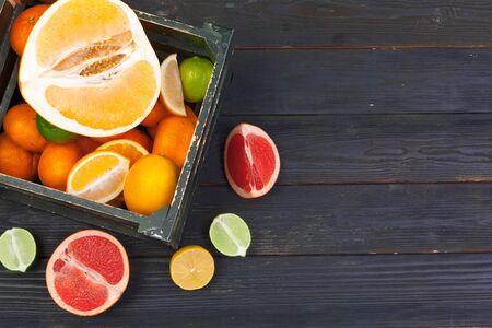 Bright composition of citrus fruits on black wooden background. creative photo.の写真素材