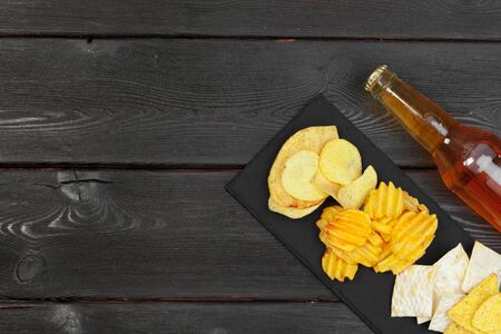 Lager beer and snacks on wooden table.