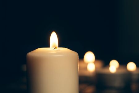 candles burning in darkness over black background. commemoration concept.の写真素材