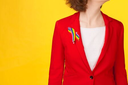 homosexual and lgbt concept - close up of woman wearing gay pride awareness ribbon on her chestの写真素材