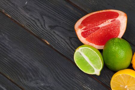 Citrus fruits slice on a black wooden background. Creative photo.の写真素材