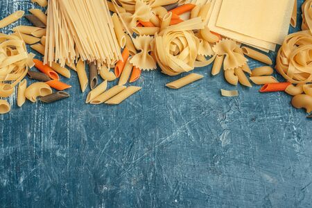 Various types of Italian pasta rustic background