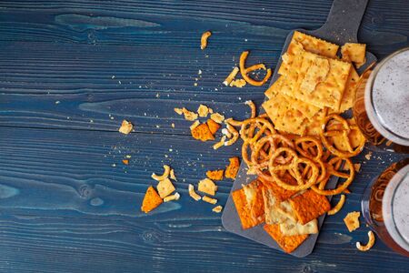 Scattered beer snacks assortment on blue wooden background. creative photo.の写真素材