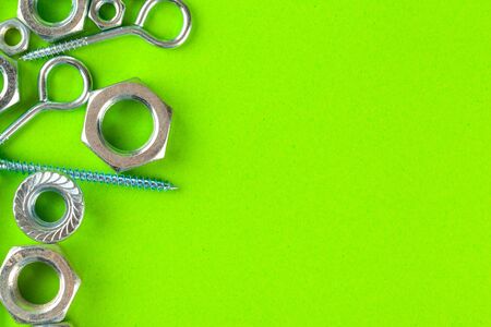 Engineering tools. Bolts and nuts on green background. creative photo.の写真素材