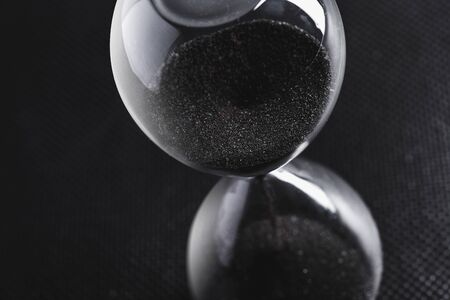 Hourglass on dark background. creative photo.