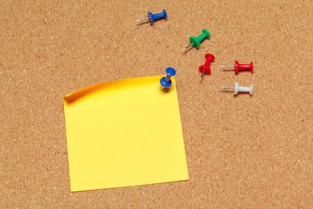 colorful sticky notes with pushpins and blank space, on cork background