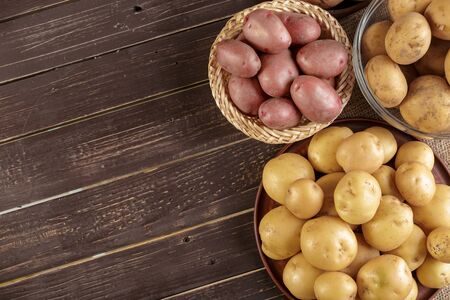 Fresh potatoes on the wood background