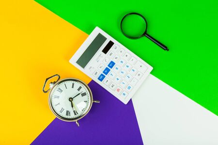 Black alarm clock on color block background, office interior. creative photo.の写真素材