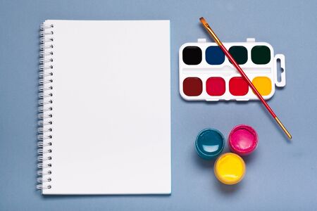 Paper, watercolors, paint brush and some art stuff close up top view. creative photo.の写真素材