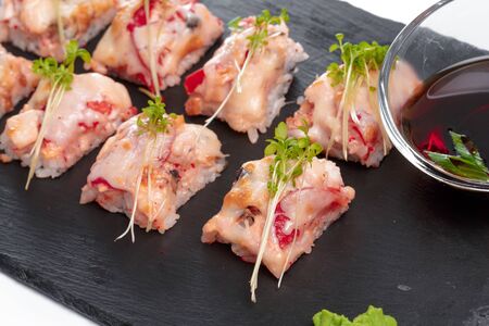 Black rectangle plate with sushi, isolated on white. creative photo.