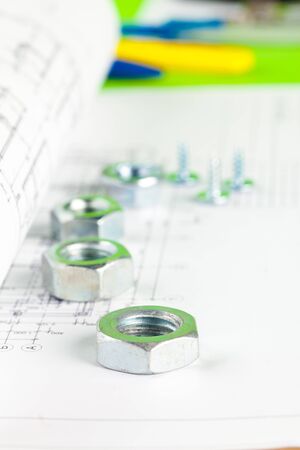 Nuts and bolts close-up over house plan. creative photo.