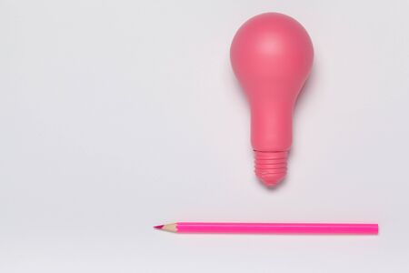 Creative idea concept. Pink lightbulb and pencil top view. creative photo.