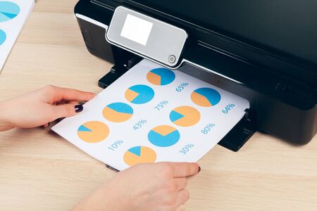 Female secretary making photocopies on machine in officeの写真素材