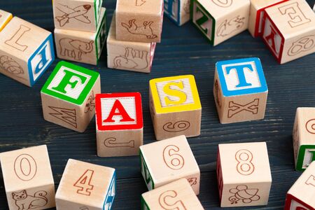 Alphabet blocks ABC on wooden table. Text - Fast creative photo.