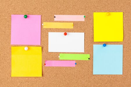 Cork board with several colorful blank notes with pinsの写真素材