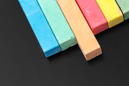 Set of colored chalks over a black background. creative photo.