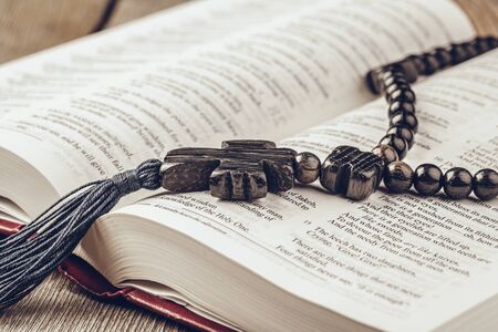 Bible and a crucifix on an old wooden table. Religion concept.の写真素材